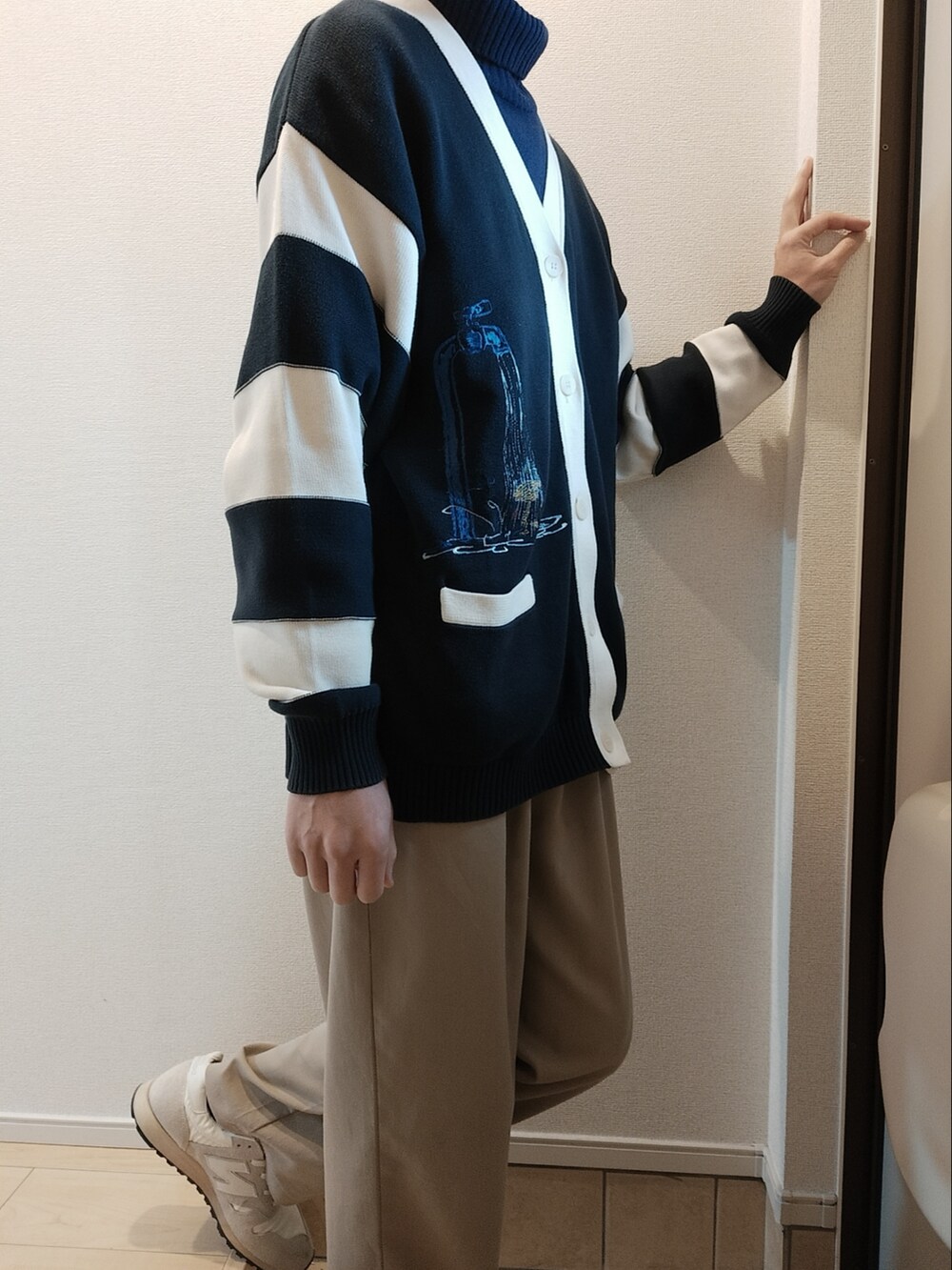 ベージュ系のスラックス、ブルー系のニット/セーター、ブルー系のカーディガン/ボレロを着用したメンズの春コーディネートの2枚目の写真