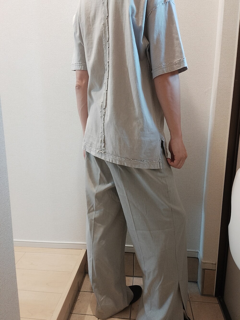 グレー系のスラックス、ホワイト系のTシャツ/カットソーを着用したメンズの夏コーディネートの3枚目の写真