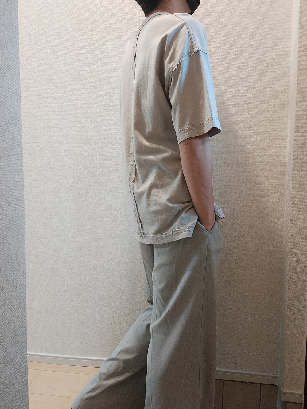 グレー系のスラックス、ホワイト系のTシャツ/カットソーを着用したメンズの夏コーディネートの2枚目の写真