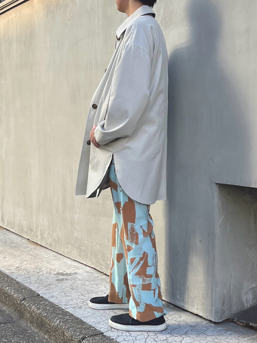 ベージュ系のステンカラーコート、ブルー系のその他パンツを着用したレディースの冬コーディネートの2枚目の写真