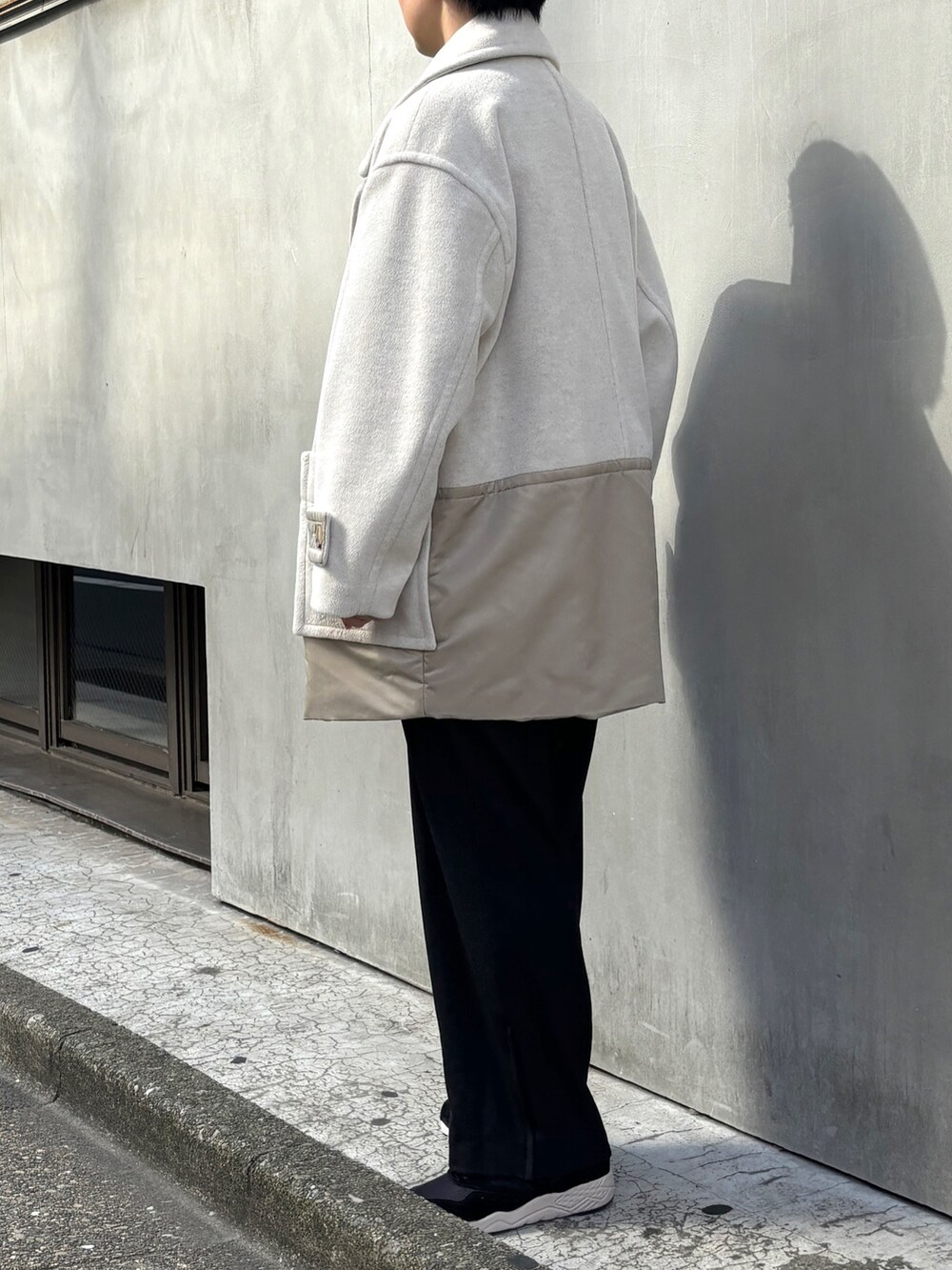 ホワイト系のピーコート、グリーン系のニット/セーター、ブラック系のその他パンツを着用したレディースの冬コーディネートの2枚目の写真