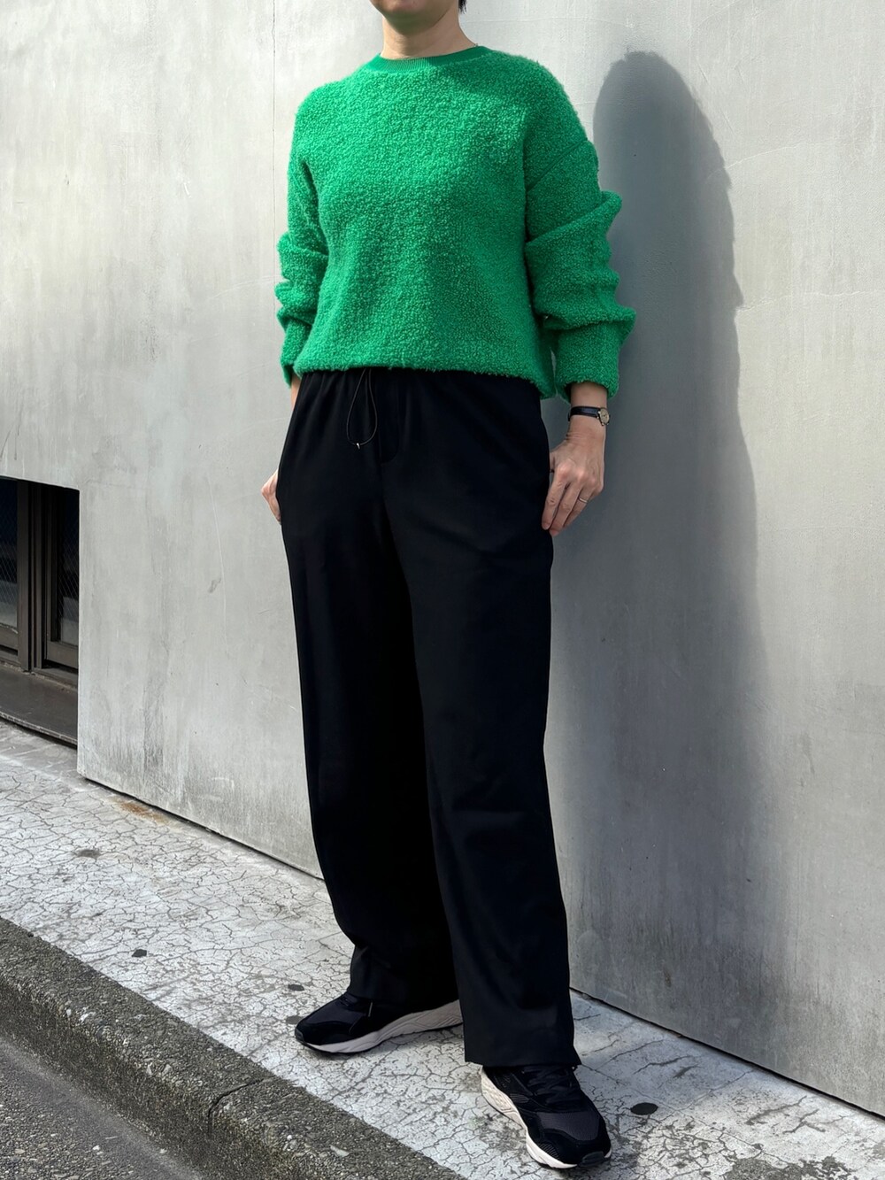 ホワイト系のピーコート、グリーン系のニット/セーター、ブラック系のその他パンツを着用したレディースの冬コーディネートの3枚目の写真