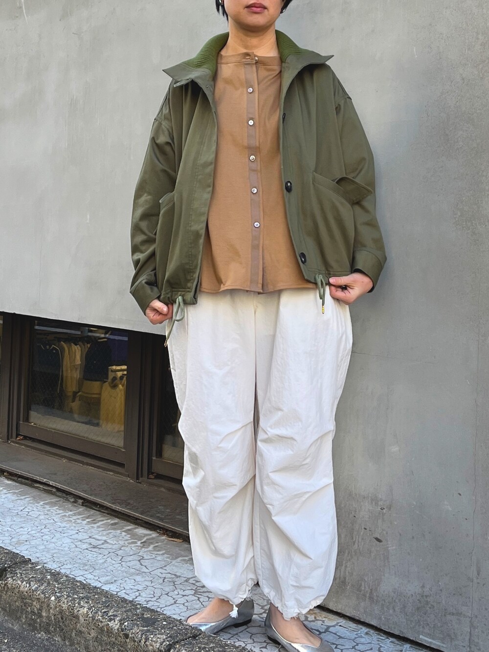 グリーン系のブルゾン、ホワイト系のその他パンツを着用したレディースの冬コーディネートの2枚目の写真