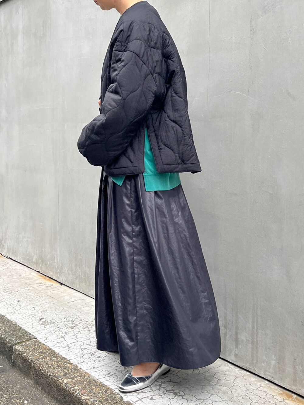 ブラック系のブルゾン、ブラック系のスカート、グリーン系のTシャツ/カットソーを着用したレディースの秋コーディネートの2枚目の写真