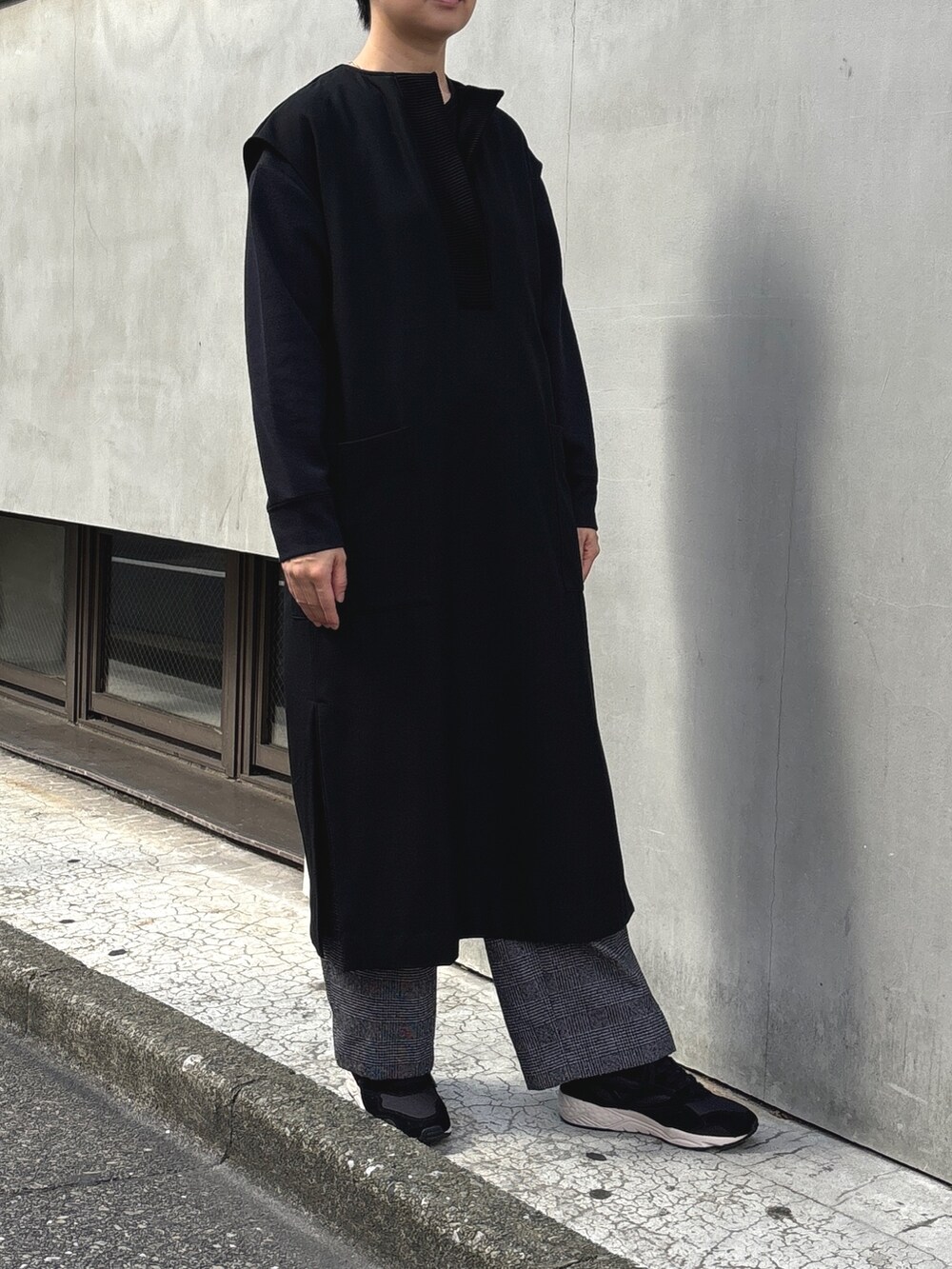 ブラウン系のチェスターコート、ブラック系のワンピース、ブラック系のその他パンツを着用したレディースの冬コーディネートの3枚目の写真