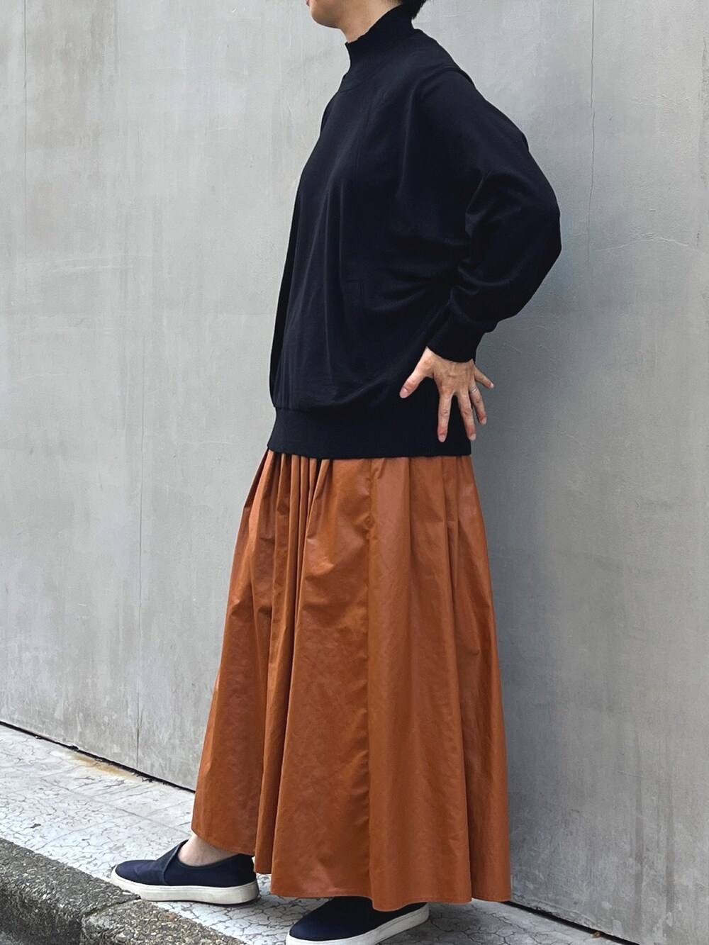 グレー系のムートンコート、レッド系のスカート、ブラック系のTシャツ/カットソーを着用したレディースの秋コーディネートの3枚目の写真