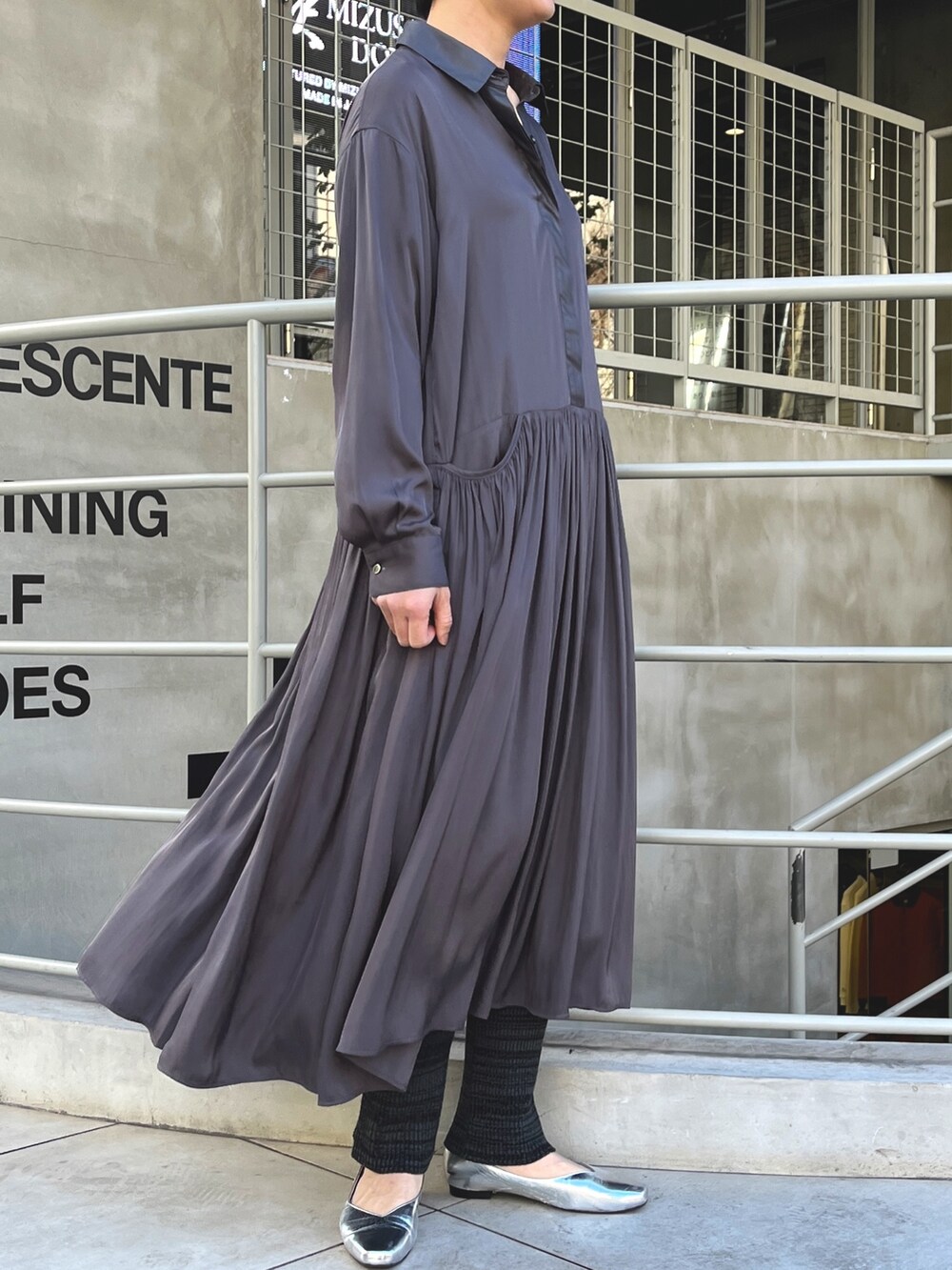 ベージュ系のブルゾン、グレー系のワンピース、ブラック系のその他パンツを着用したレディースの冬コーディネートの2枚目の写真