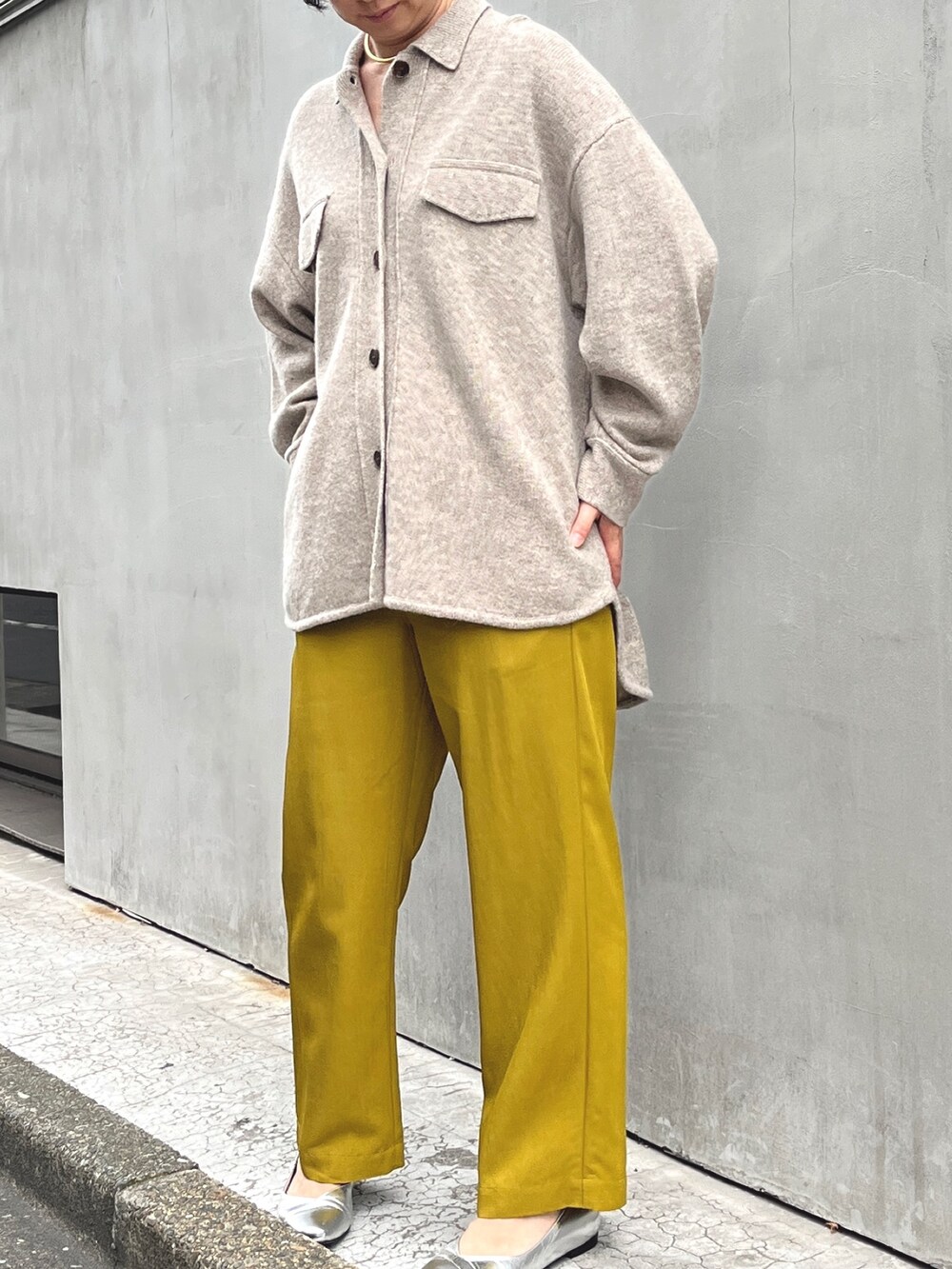 イエロー系のその他パンツ、ブラック系のダウンジャケット/コート、ベージュ系のシャツ/ブラウスを着用したレディースの秋コーディネートの2枚目の写真