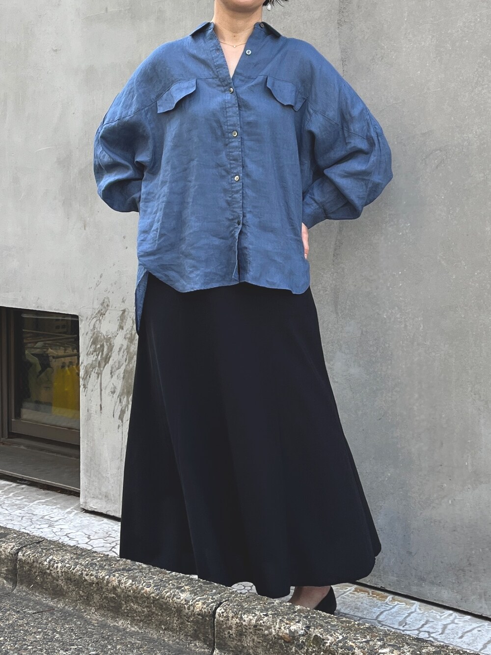 ブルー系のシャツ/ブラウス、ブラック系のスカートを着用したレディースの春コーディネートの3枚目の写真