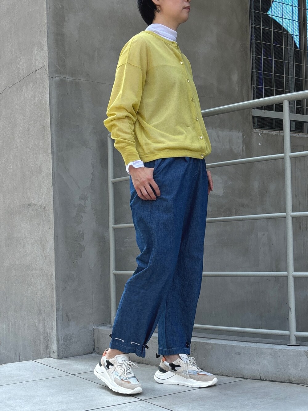 ブルー系のデニムパンツを着用したレディースの秋コーディネートの2枚目の写真