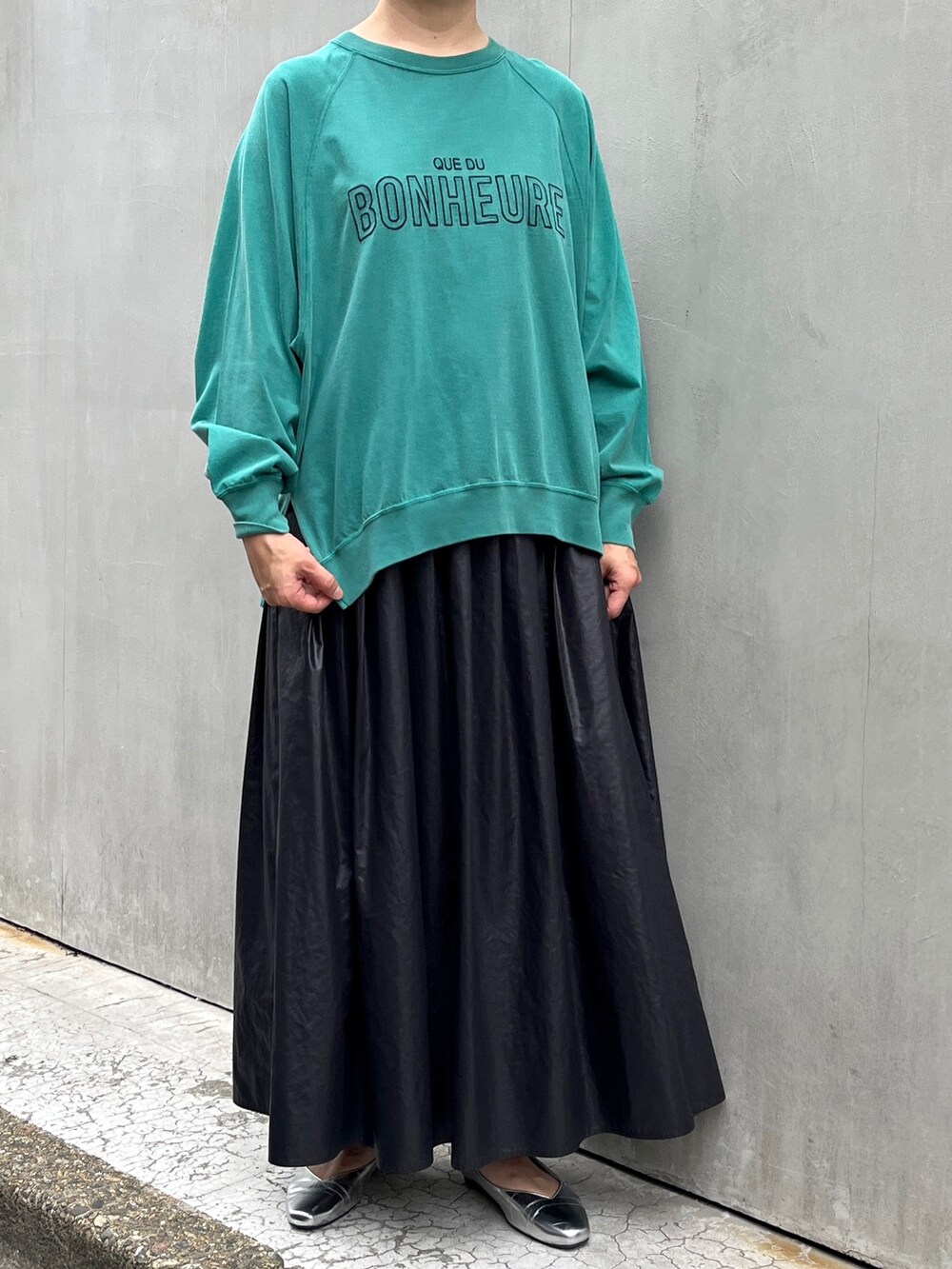 ブラック系のブルゾン、ブラック系のスカート、グリーン系のTシャツ/カットソーを着用したレディースの秋コーディネートの3枚目の写真