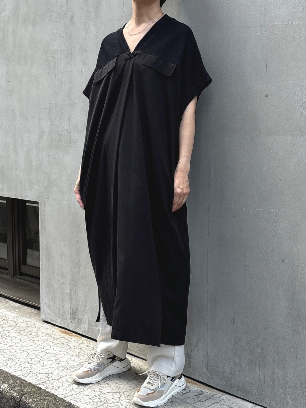 ベージュ系のブルゾン、ブラック系のワンピースを着用したレディースの夏コーディネートの3枚目の写真