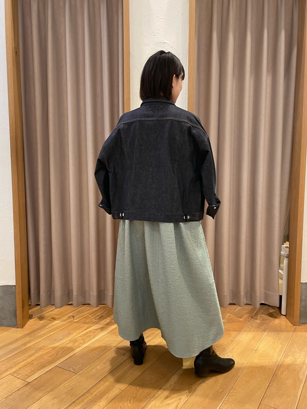 グリーン系のワンピース、ホワイト系のTシャツ/カットソー、ブルー系のデニムジャケットを着用したレディースの冬コーディネートの3枚目の写真