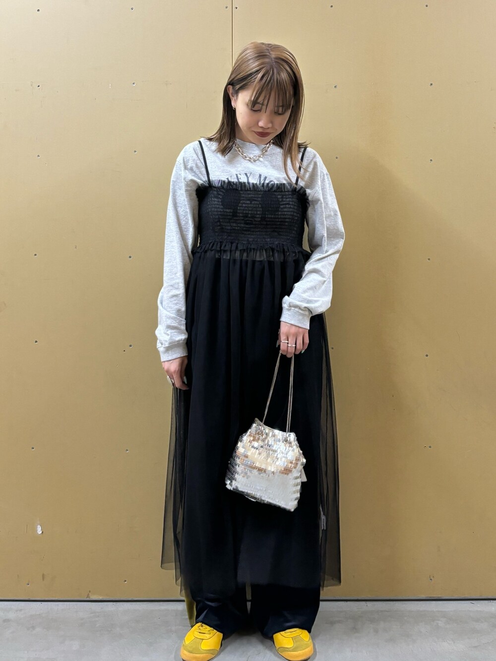 グレー系のTシャツ/カットソー、シルバー系のショルダーバッグ、ブラック系のワンピースを着用したレディースの冬コーディネートの2枚目の写真