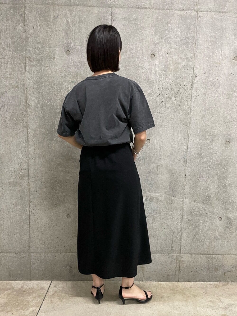 ブラック系のスカート、ブラック系のTシャツ/カットソーを着用したレディースの夏コーディネートの2枚目の写真
