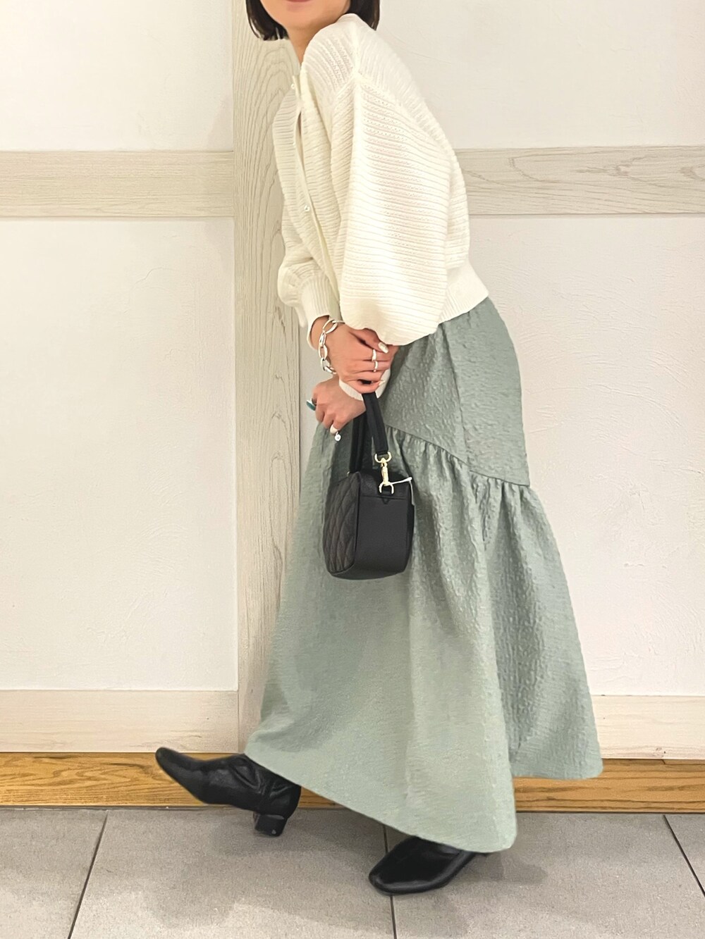 ホワイト系のカーディガン/ボレロ、ホワイト系のショルダーバッグ、グリーン系のスカートを着用したレディースの春コーディネートの3枚目の写真