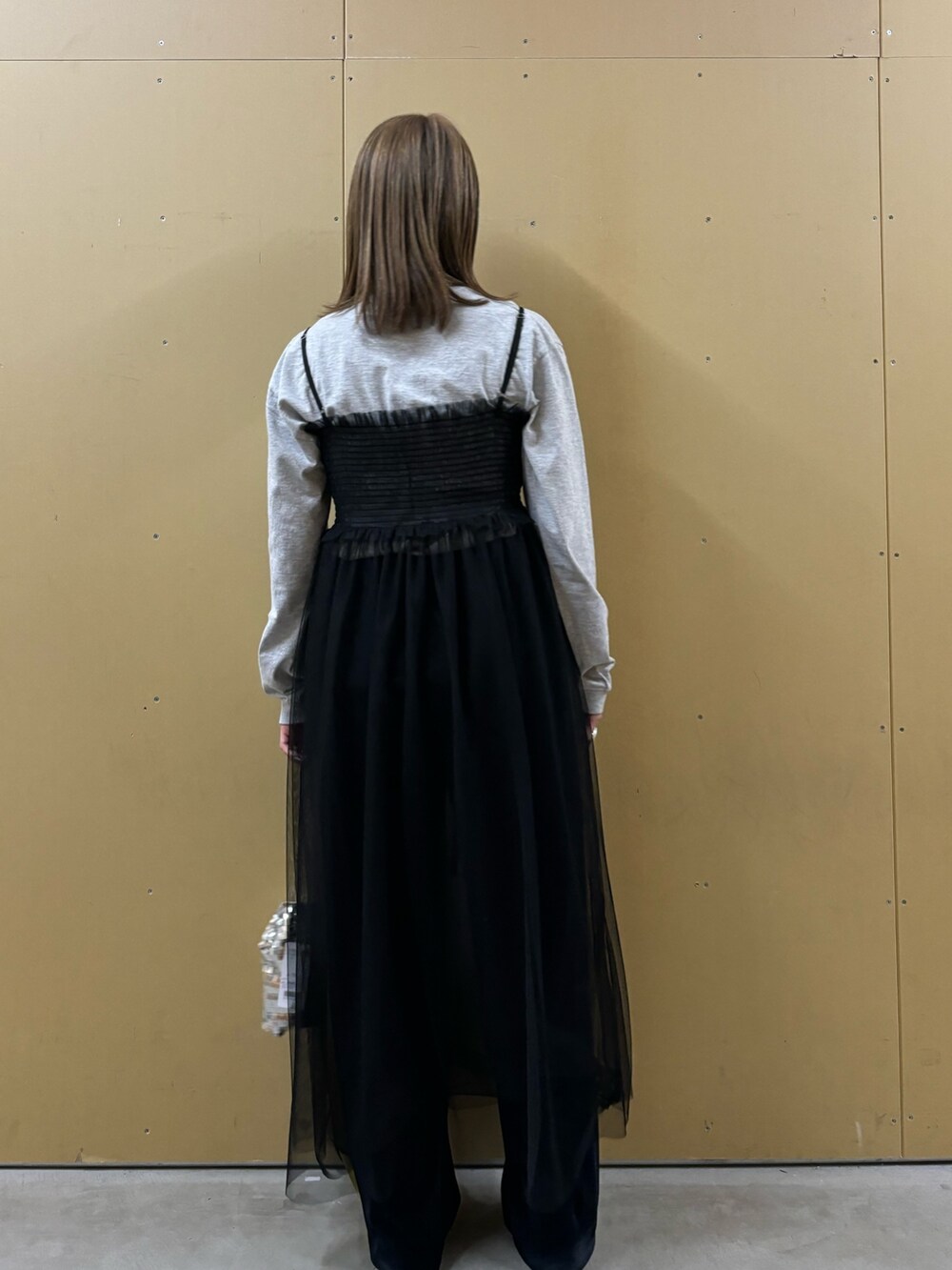 グレー系のTシャツ/カットソー、シルバー系のショルダーバッグ、ブラック系のワンピースを着用したレディースの冬コーディネートの4枚目の写真