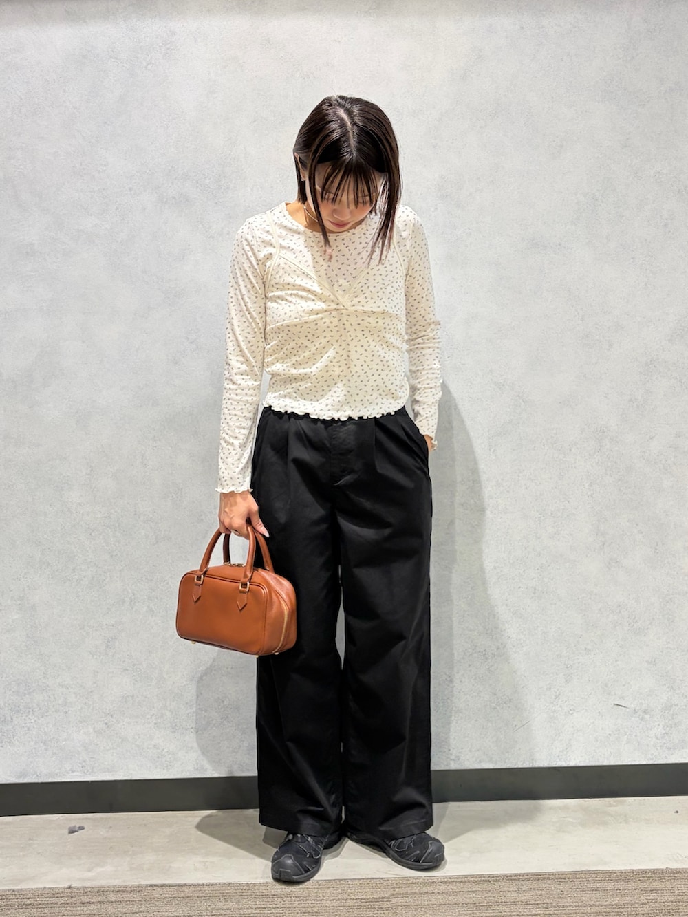ベージュ系のその他パンツ、ホワイト系のTシャツ/カットソー、ブラウン系のボストンバッグを着用したレディースの秋コーディネートの2枚目の写真