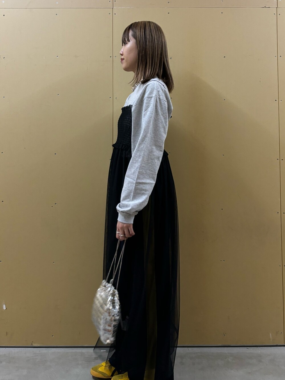 グレー系のTシャツ/カットソー、シルバー系のショルダーバッグ、ブラック系のワンピースを着用したレディースの冬コーディネートの3枚目の写真