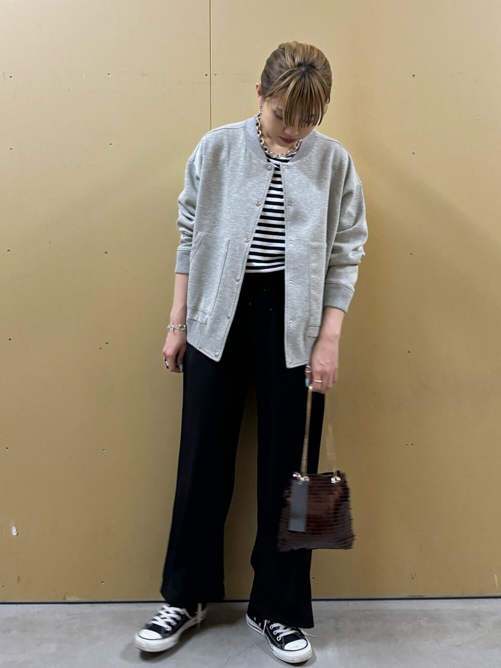 シルバー系のショルダーバッグ、ブラック系のその他パンツ、グレー系のブルゾンを着用したレディースの春コーディネートの2枚目の写真