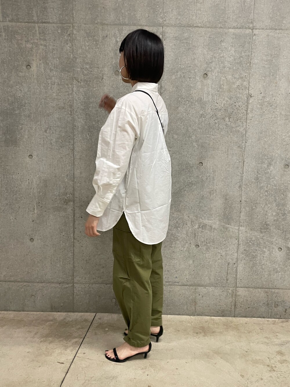 ホワイト系のシャツ/ブラウス、グリーン系のカーゴパンツ、ブラック系のショルダーバッグを着用したレディースの春コーディネートの2枚目の写真