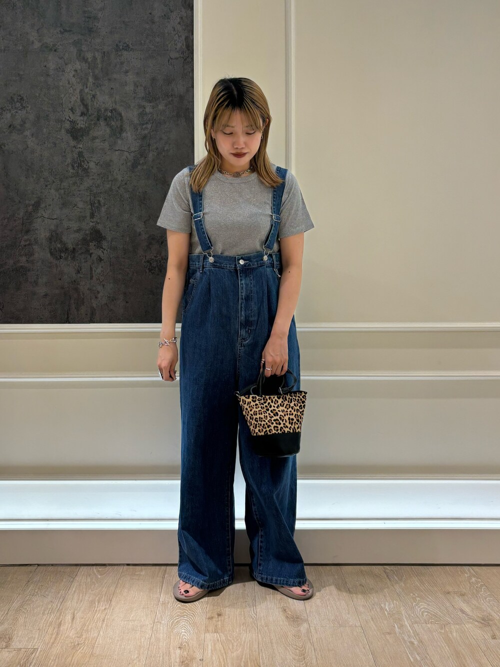 ブルー系のデニムパンツ、ブラック系のサンダル、ベージュ系のショルダーバッグを着用したレディースの夏コーディネートの2枚目の写真