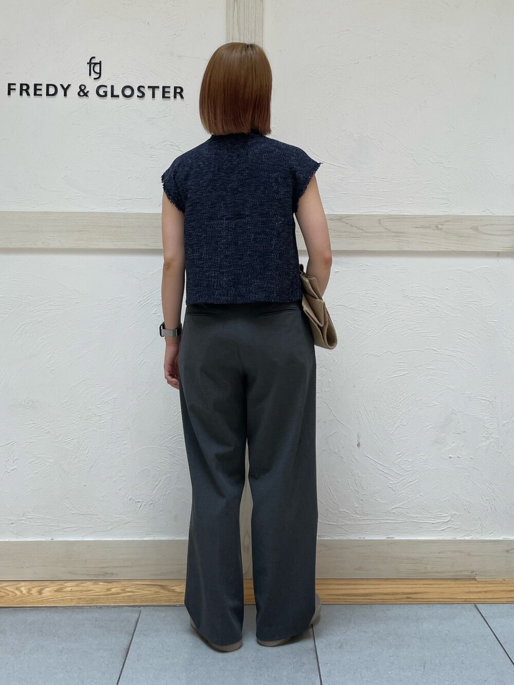 ホワイト系のトートバッグ、ブルー系のシャツ/ブラウス、ベージュ系のサンダルを着用したレディースの夏コーディネートの3枚目の写真