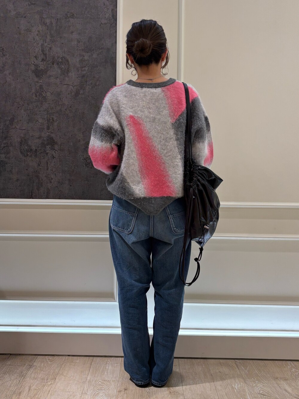 ブラック系のバックパック/リュック、グレー系のニット/セーターを着用したレディースの冬コーディネートの2枚目の写真