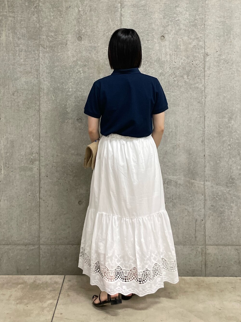 ブルー系のTシャツ/カットソー、ホワイト系のスカート、ホワイト系のトートバッグを着用したレディースの春コーディネートの3枚目の写真