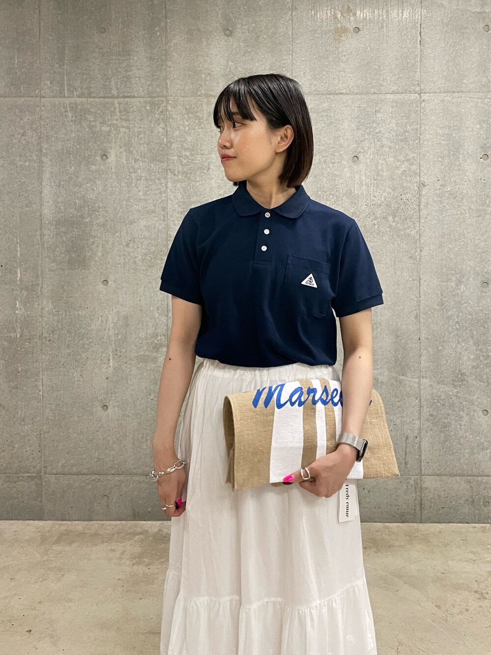 ブルー系のTシャツ/カットソー、ホワイト系のスカート、ホワイト系のトートバッグを着用したレディースの春コーディネートの4枚目の写真