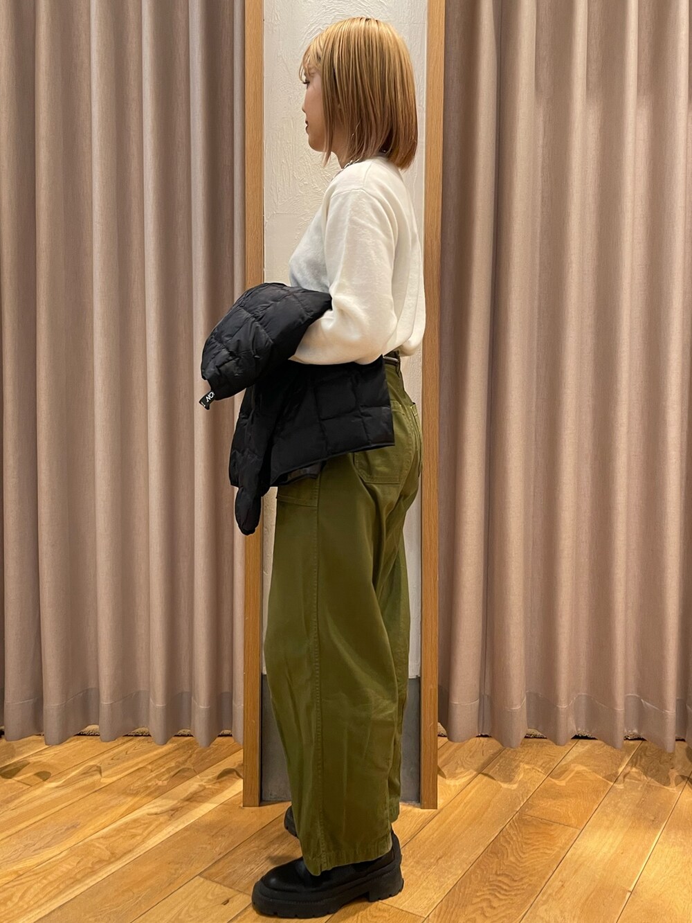 ベージュ系のダウンジャケット/コート、ホワイト系のニット/セーターを着用したレディースの秋コーディネートの2枚目の写真