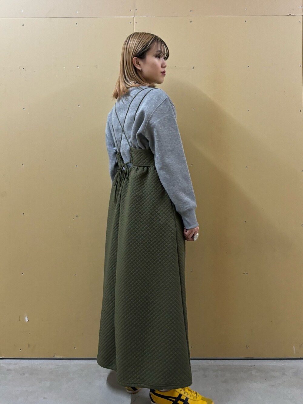 グリーン系のワンピース、グレー系のスウェットを着用したレディースの冬コーディネートの3枚目の写真