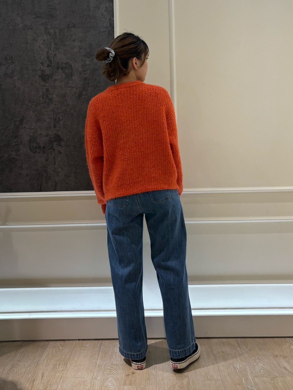 ブルー系のデニムパンツ、オレンジ系のカーディガン/ボレロを着用したレディースの秋コーディネートの2枚目の写真