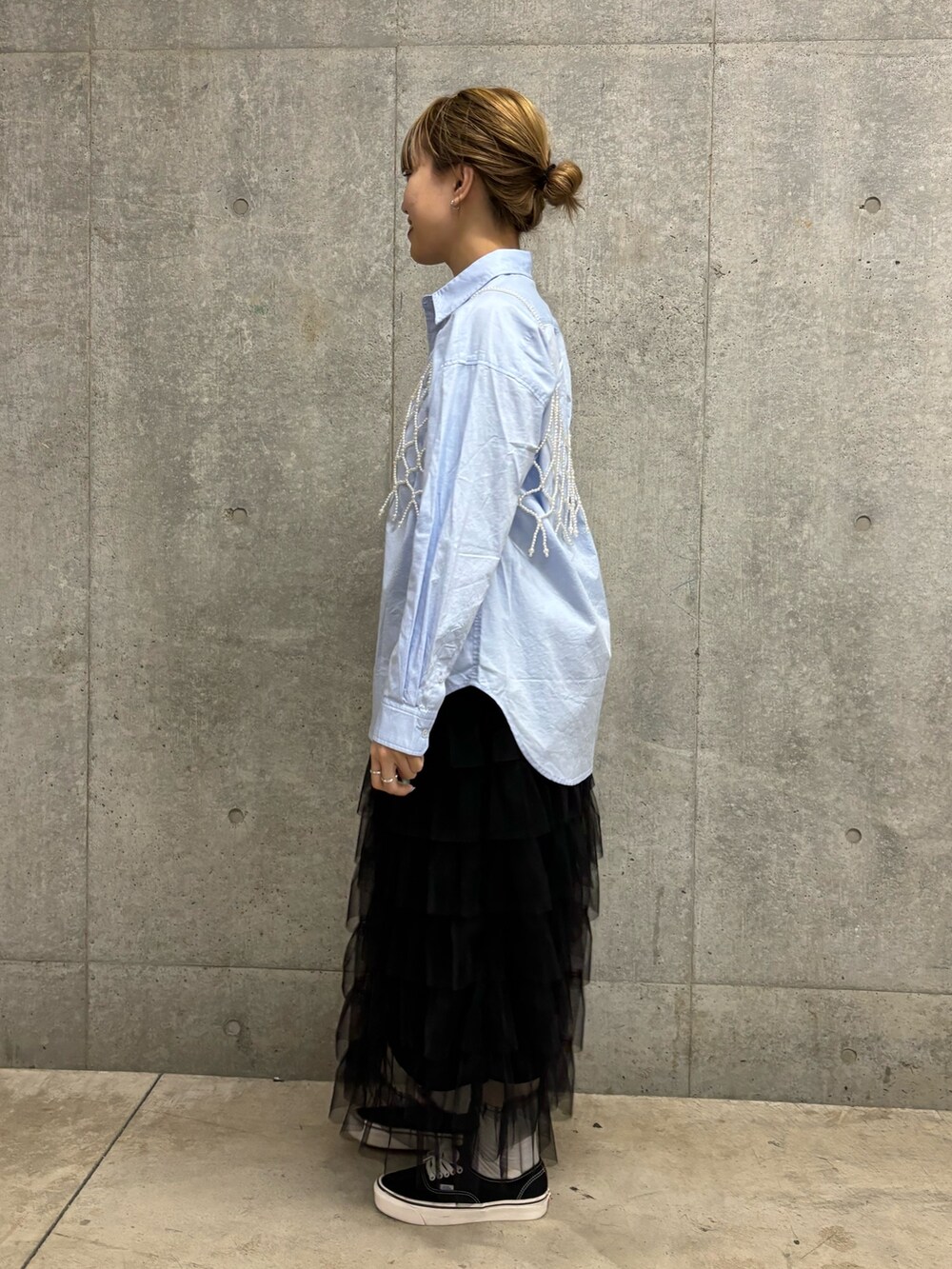 シルバー系のショルダーバッグ、ホワイト系のスカート、ホワイト系のシャツ/ブラウスを着用したレディースの春コーディネートの2枚目の写真