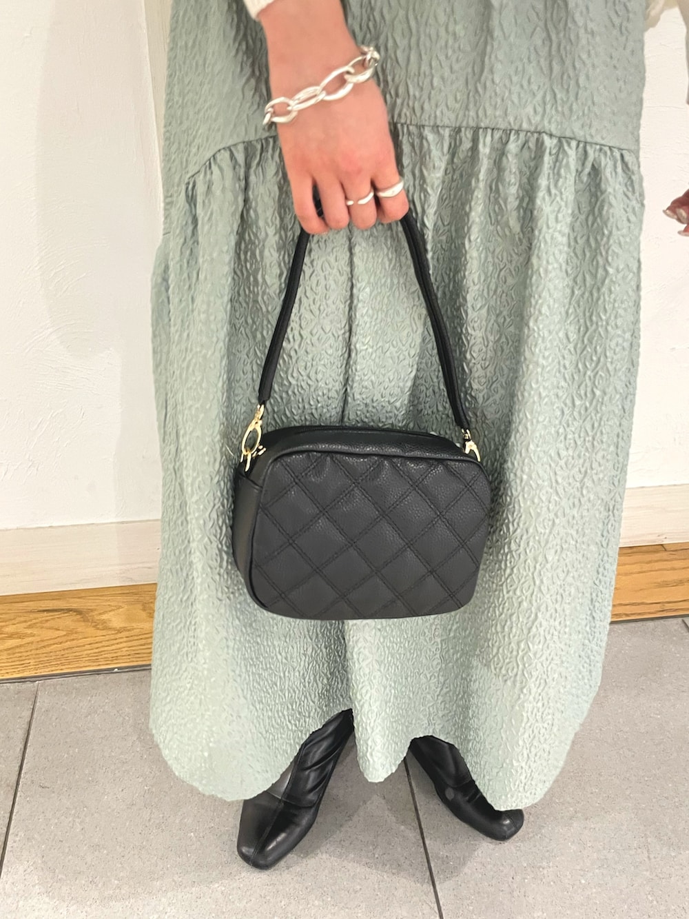 ホワイト系のカーディガン/ボレロ、ホワイト系のショルダーバッグ、グリーン系のスカートを着用したレディースの春コーディネートの5枚目の写真