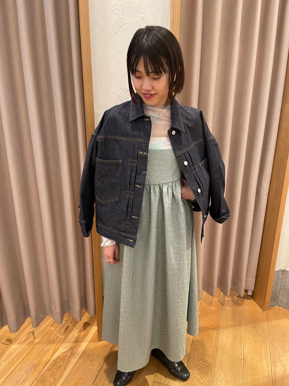 グリーン系のワンピース、ホワイト系のTシャツ/カットソー、ブルー系のデニムジャケットを着用したレディースの冬コーディネートの4枚目の写真