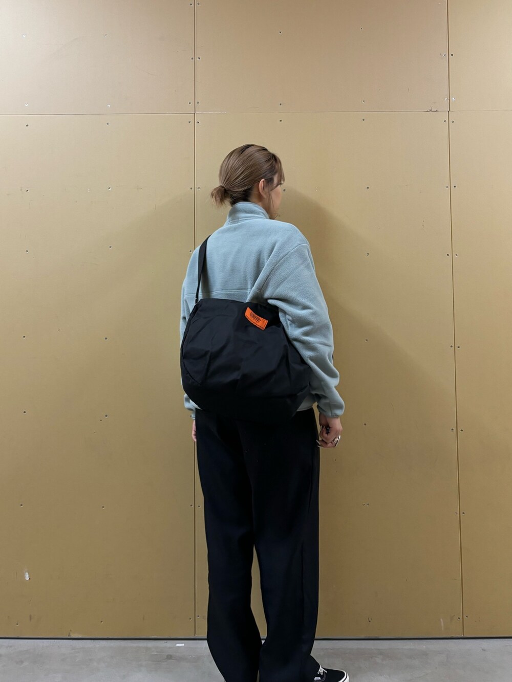 ブラック系のショルダーバッグ、ブルー系のブルゾンを着用したレディースの秋コーディネートの3枚目の写真