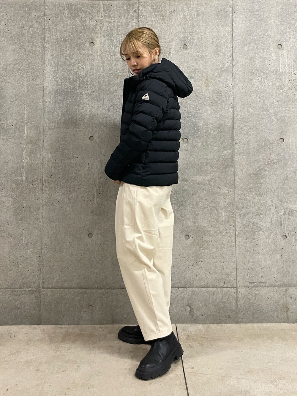 ブラック系のダウンジャケット/コート、ホワイト系のその他パンツを着用したレディースの秋コーディネートの2枚目の写真