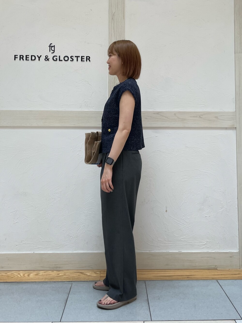 ホワイト系のトートバッグ、ブルー系のシャツ/ブラウス、ベージュ系のサンダルを着用したレディースの夏コーディネートの2枚目の写真