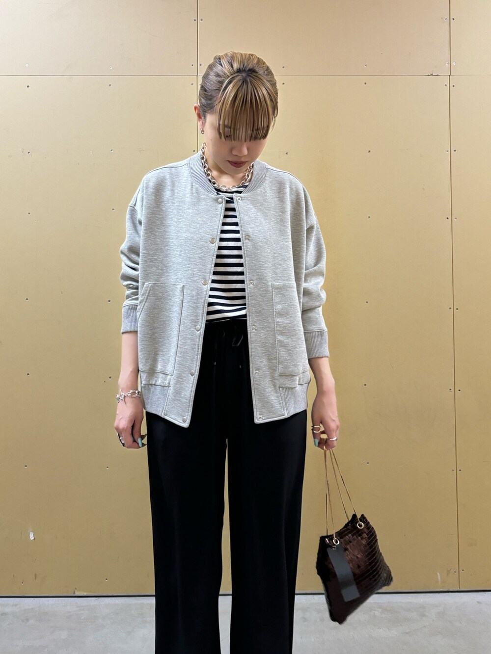 シルバー系のショルダーバッグ、ブラック系のその他パンツ、グレー系のブルゾンを着用したレディースの春コーディネートの5枚目の写真