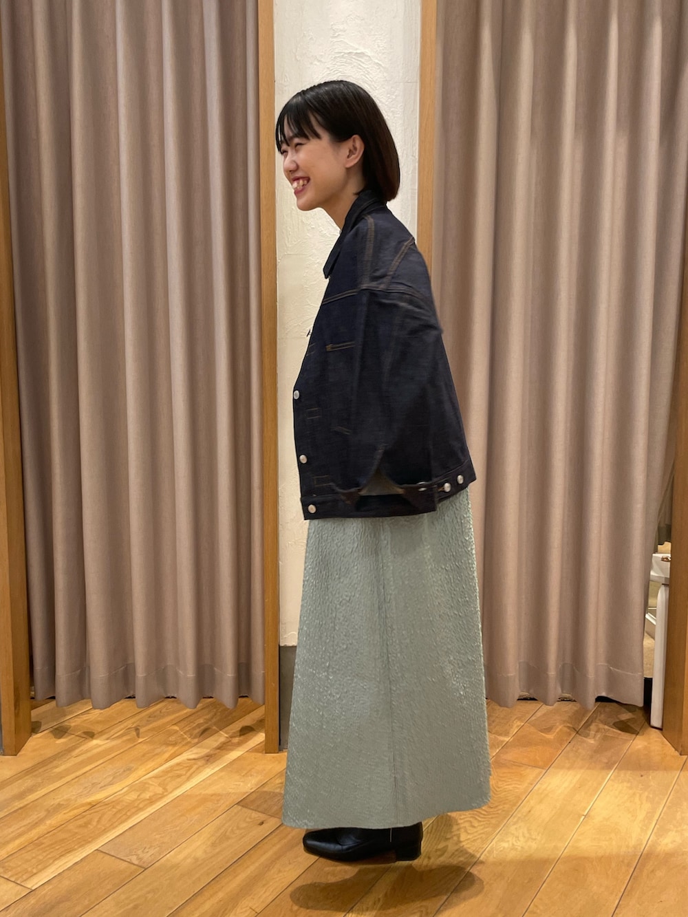 グリーン系のワンピース、ホワイト系のTシャツ/カットソー、ブルー系のデニムジャケットを着用したレディースの冬コーディネートの2枚目の写真