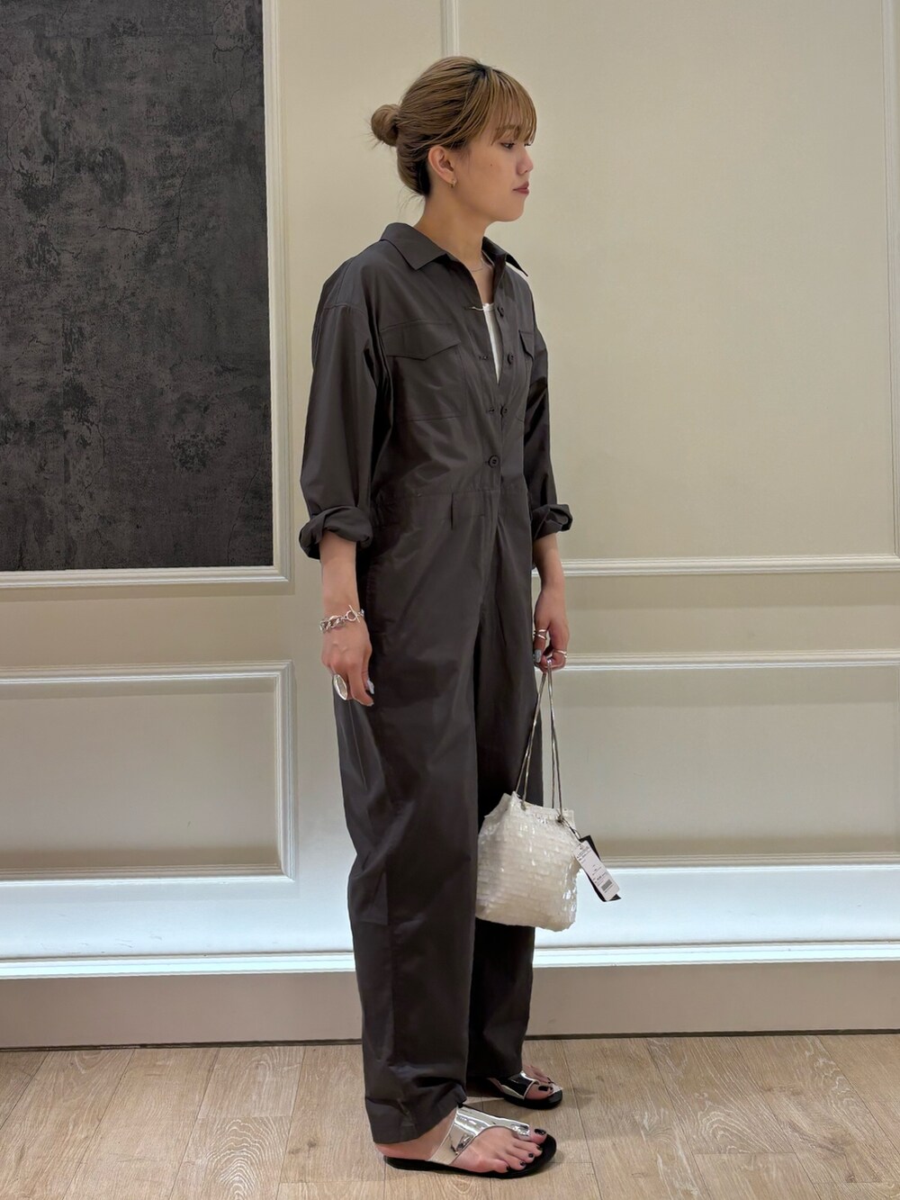 シルバー系のサンダル、シルバー系のショルダーバッグ、ホワイト系のTシャツ/カットソーを着用したレディースの夏コーディネートの2枚目の写真