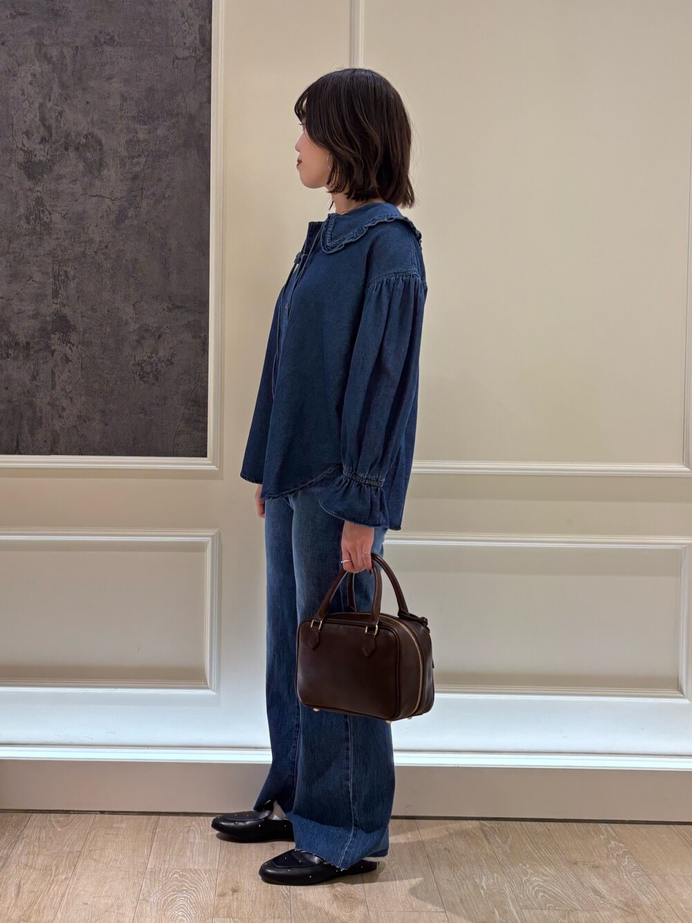 ブルー系のシャツ/ブラウス、ブラック系のハンドバッグ、ブルー系のデニムパンツを着用したレディースの冬コーディネートの2枚目の写真