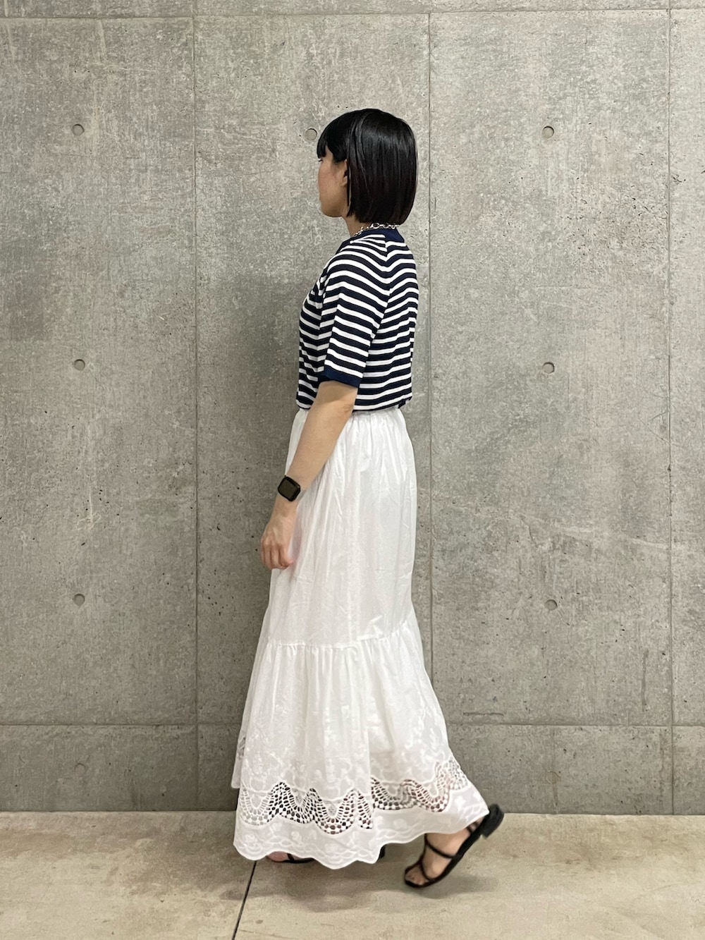 ホワイト系のスカート、ブルー系のTシャツ/カットソーを着用したレディースの夏コーディネートの2枚目の写真
