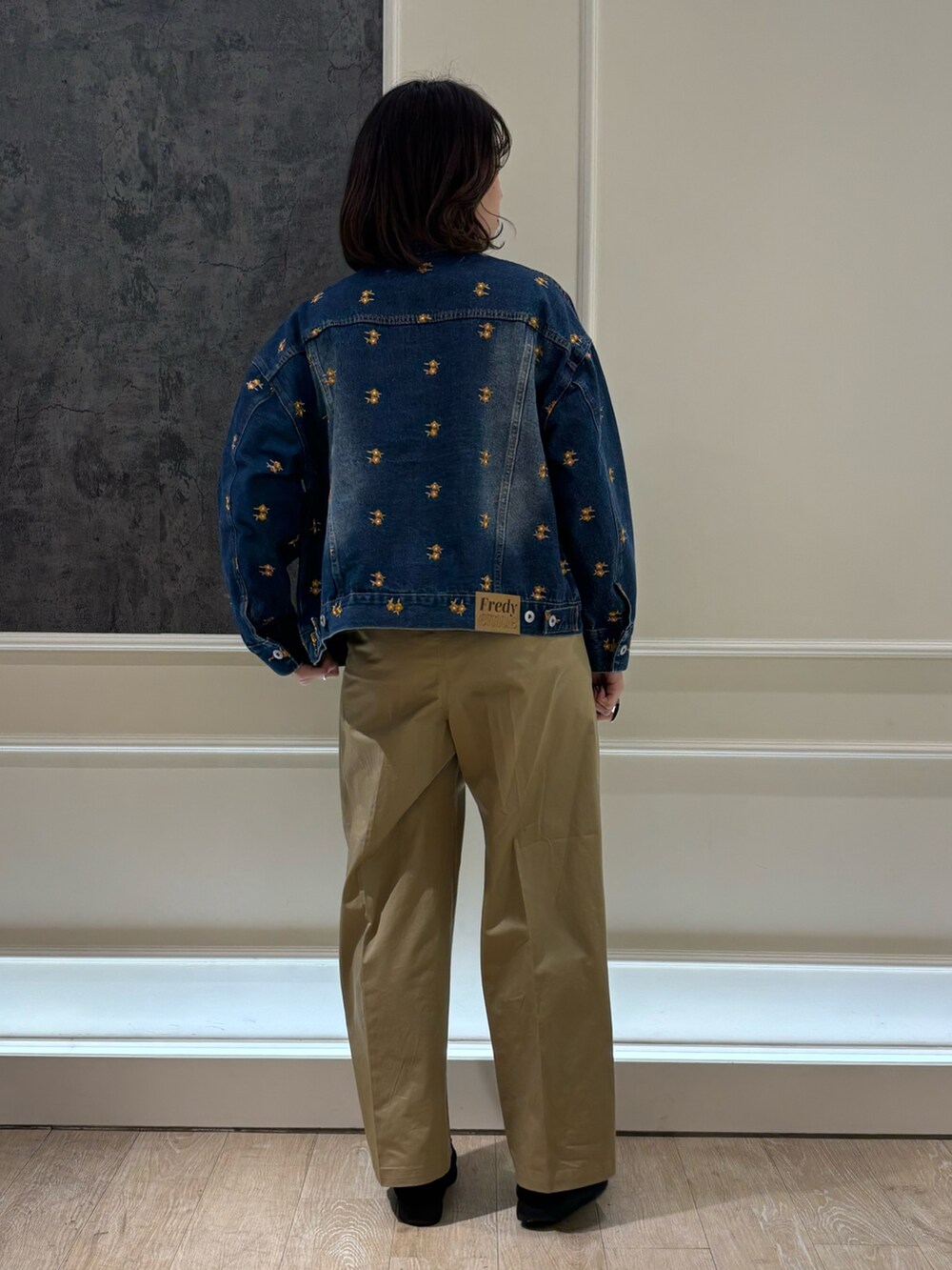 ベージュ系のチノパンツ、ブルー系のデニムジャケットを着用したレディースの冬コーディネートの2枚目の写真