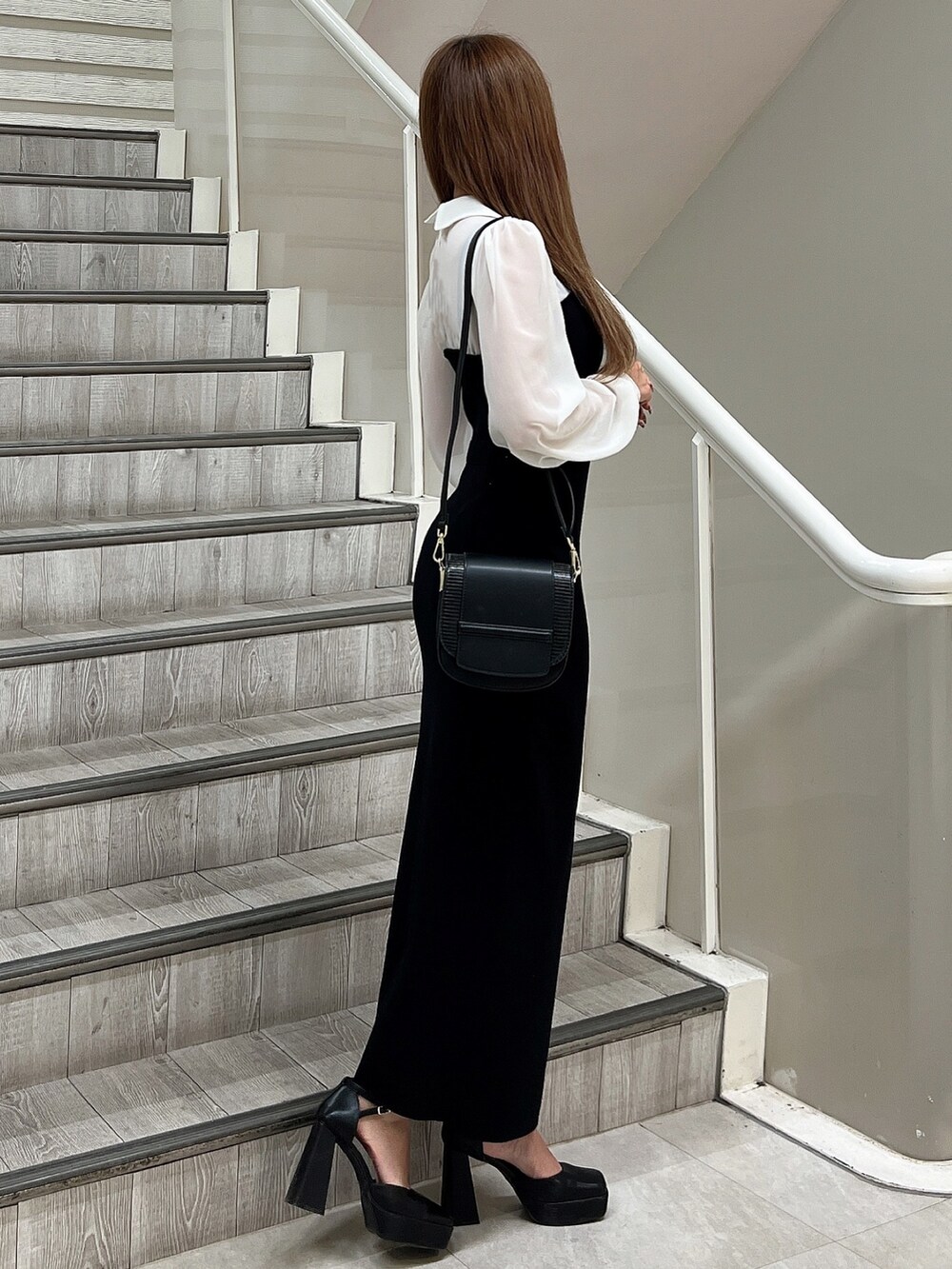 ブラック系のパンプス、ブラック系のショルダーバッグ、ブラック系のワンピースを着用したレディースの秋コーディネートの3枚目の写真