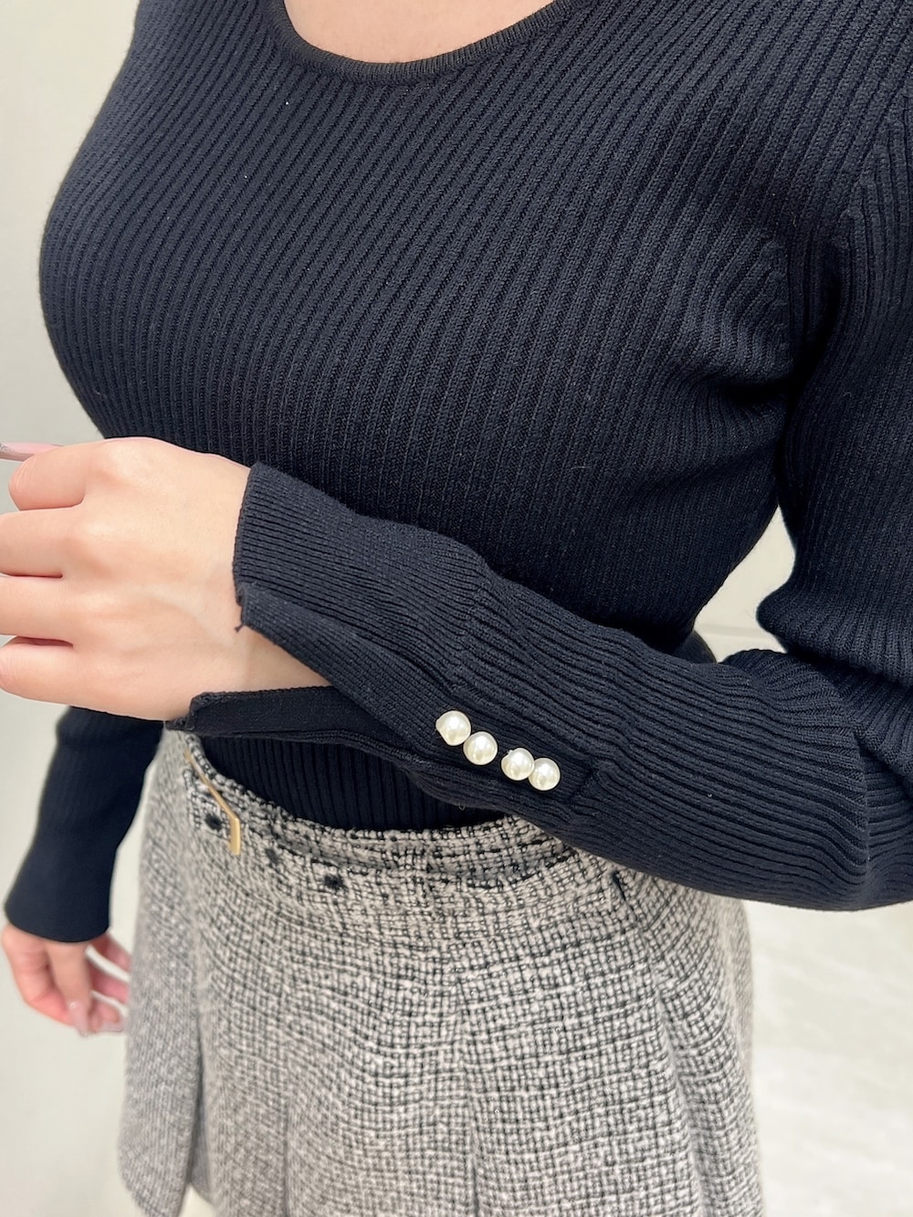 ブラック系のスカート、ブラック系のニット/セーター、ブラック系のテーラードジャケットを着用したレディースの春コーディネートの6枚目の写真