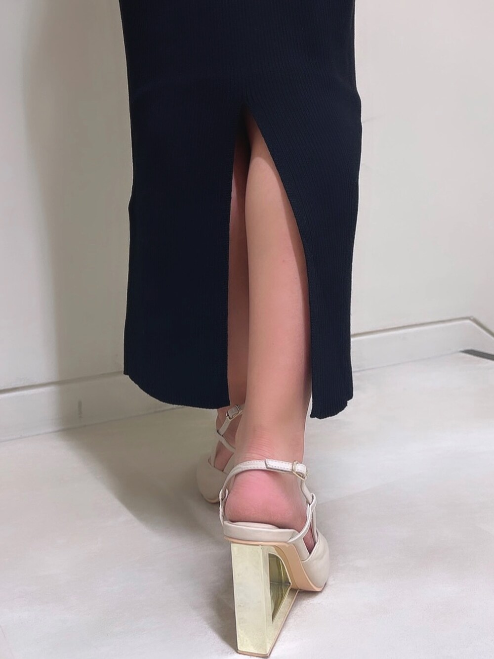 ベージュ系のライダースジャケット、ブラック系のワンピース、ベージュ系のサンダルを着用したレディースの秋コーディネートの6枚目の写真