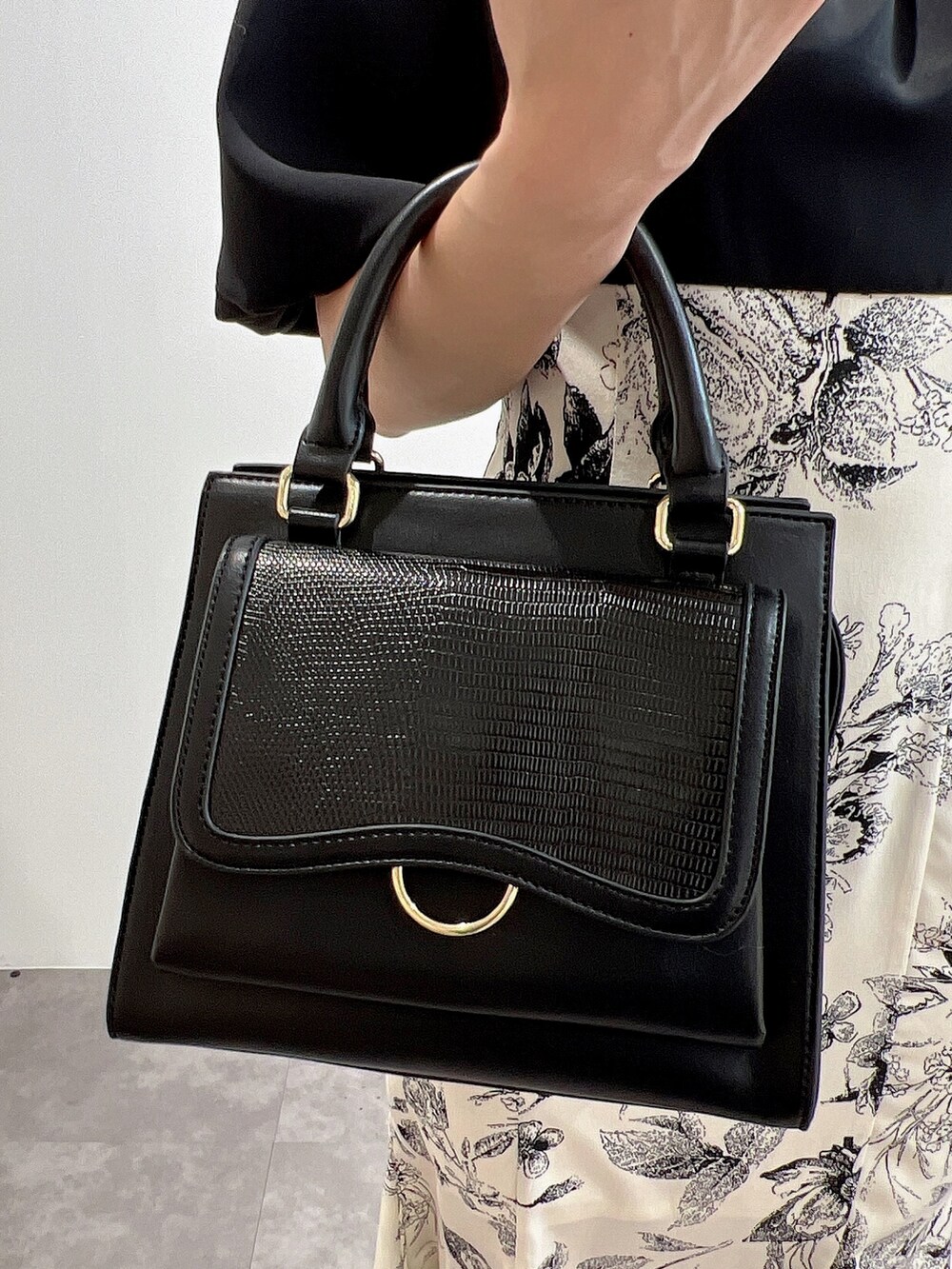 ブラック系のワンピース、ブラック系のサンダル、ブラック系のハンドバッグを着用したレディースの冬コーディネートの6枚目の写真