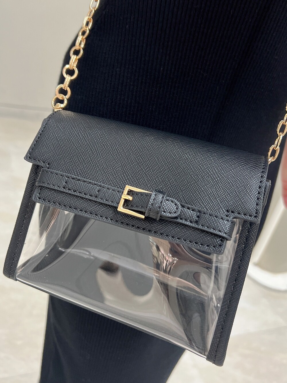 ブラック系のハンドバッグ、ホワイト系のワンピース、ブラック系のパンプスを着用したレディースの春コーディネートの7枚目の写真